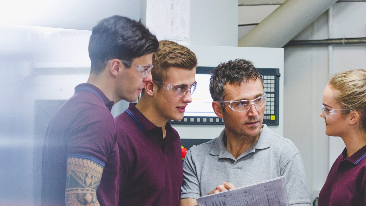 Ausbilder mit drei Auszubildenden